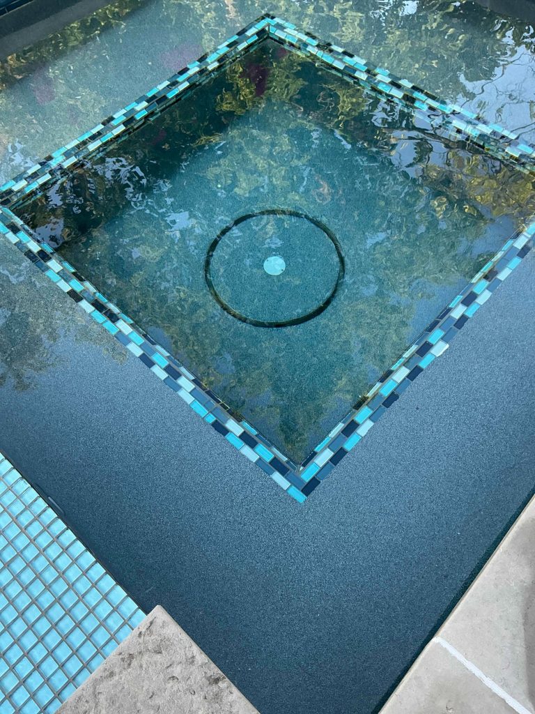 Spa bench detail showing Midnight Blue ecoFINISH interior with Avalon Series Grey Mix waterline tile.