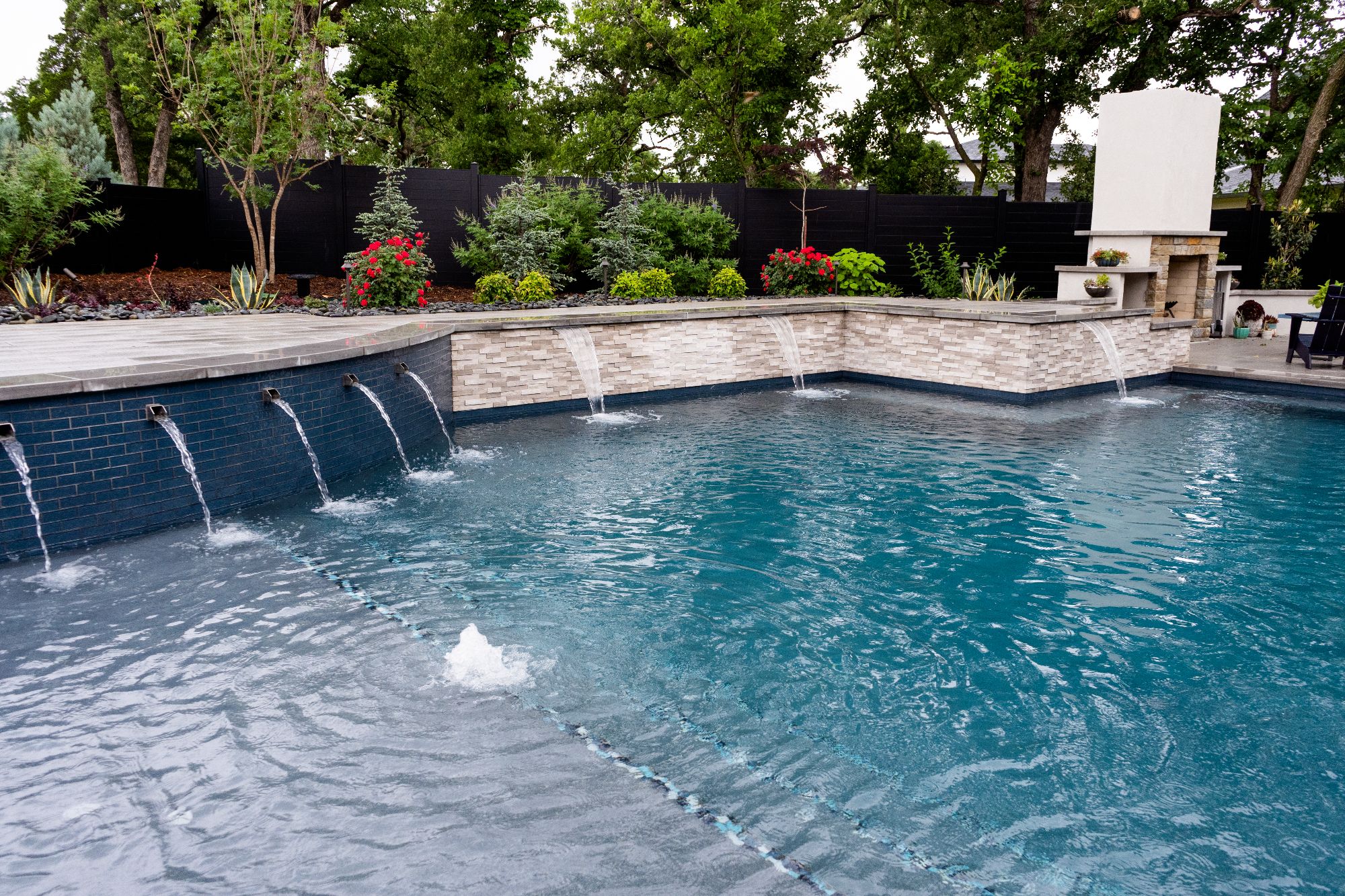 Geometric pool with raised wall water features and limestone coping in Oak Tree East Edmond Oklahoma.