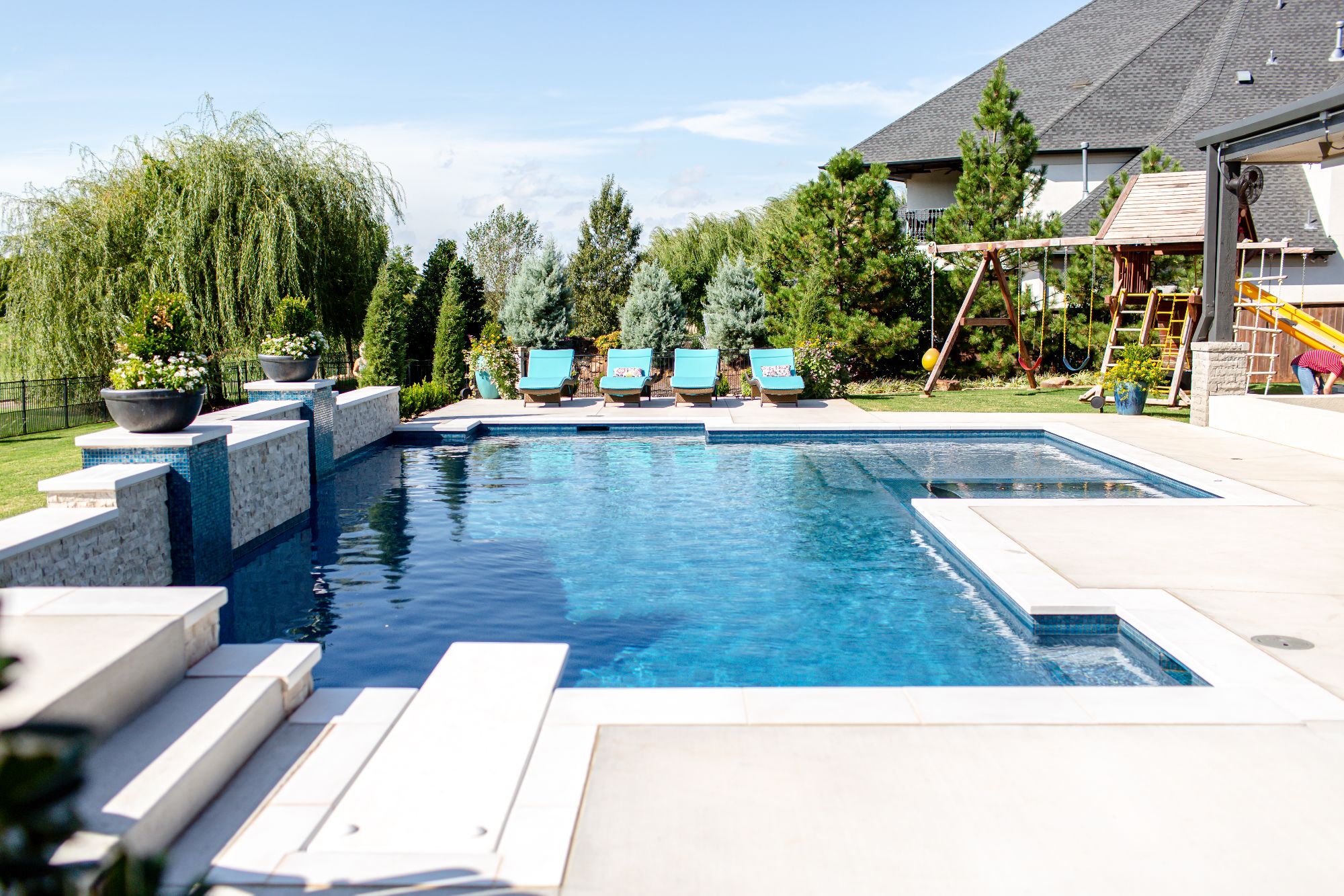 Geometric swimming pool with diving board and Mediterranean Blue ecoFINISH interior in Rose Creek Edmond Oklahoma.