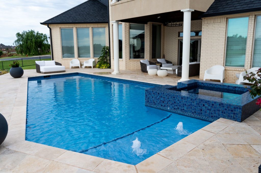 Renovated geometric pool with raised spa and travertine deck in Cobblestone Park Oklahoma City Oklahoma.
