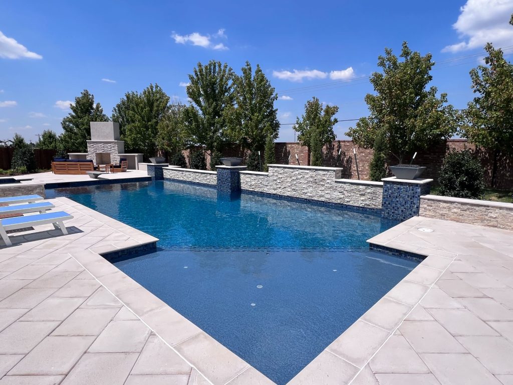 20x44 geometric swimming pool with Mediterranean Blue ecoFINISH interior and limestone paver deck in Oak Tree East Edmond Oklahoma.