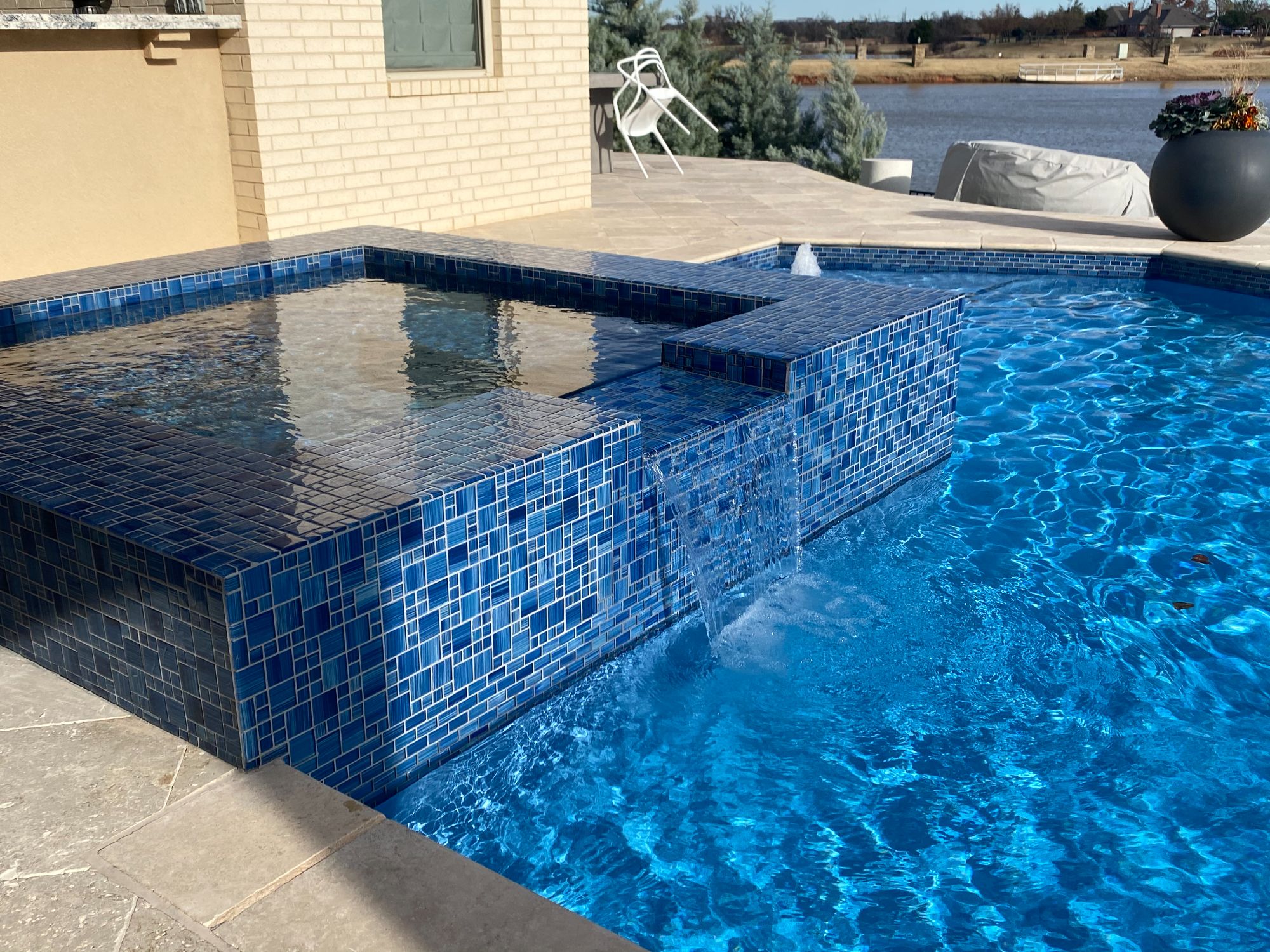 Rebuilt raised spa finished with Watercolor Caribbean Blue tile in renovated Oklahoma City pool.