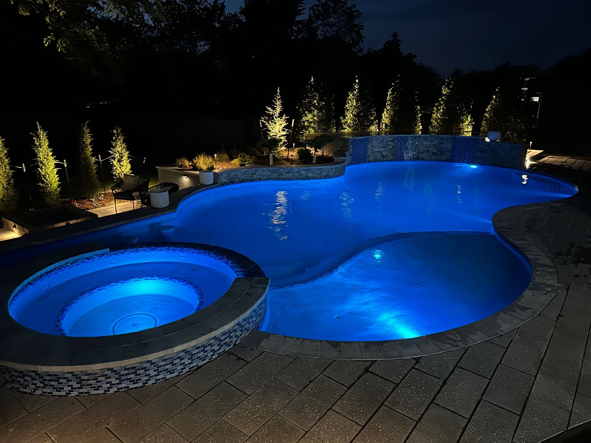 Night spa view with illuminated water by Mirage Pools & Spa in Edmond OK.